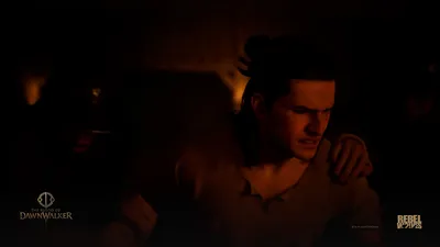 A man is seized by the shoulder in a dark room lit by firelight